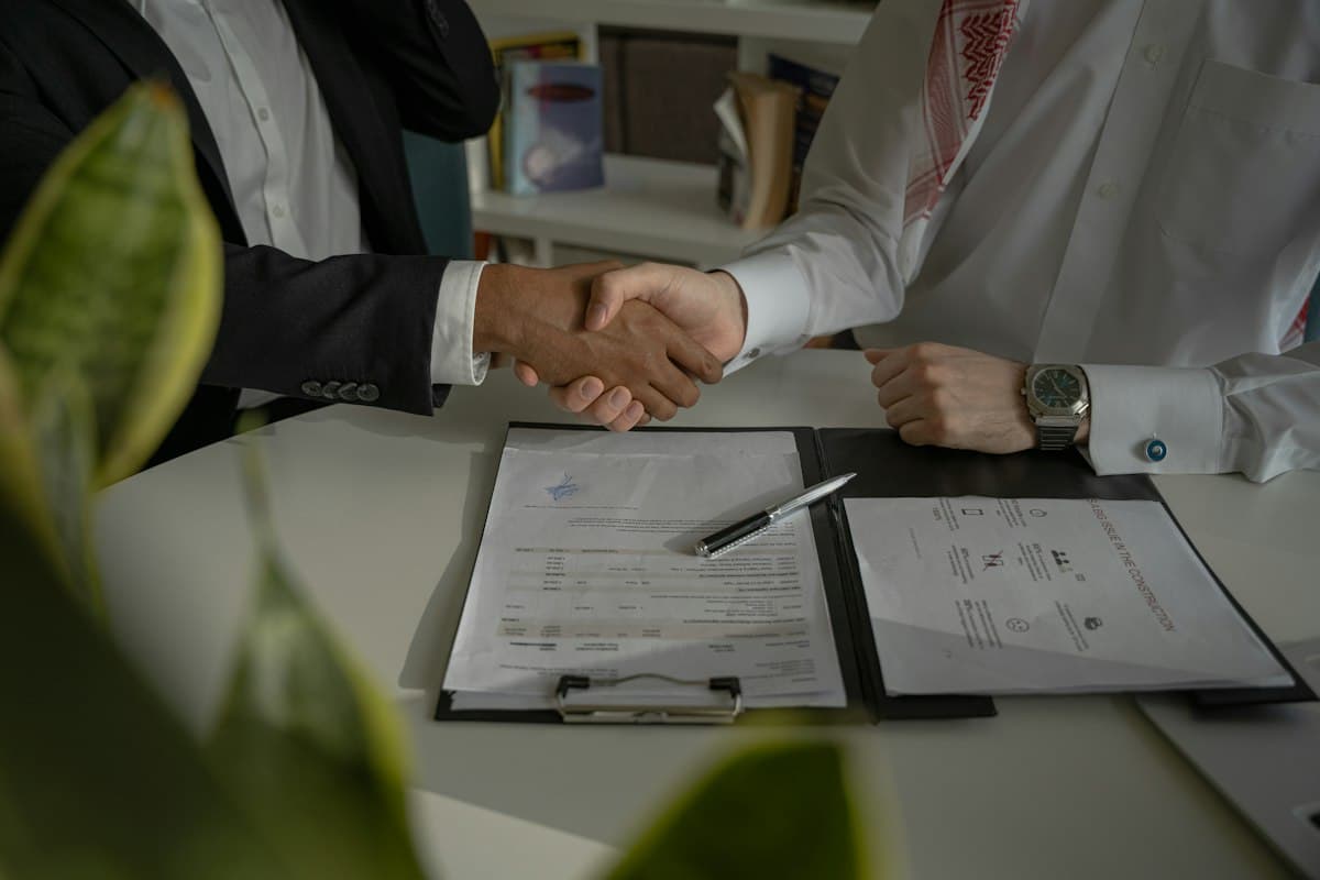 Business partners shaking hands over a signed distribution agreement